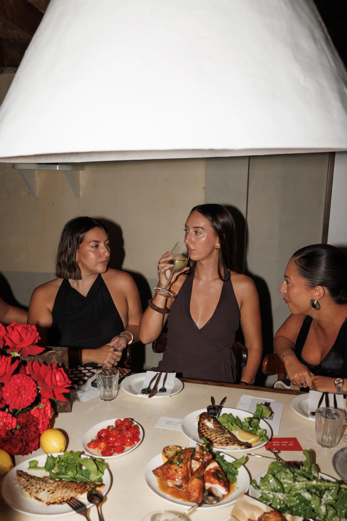 Guests around a dressed table, drinks in hand