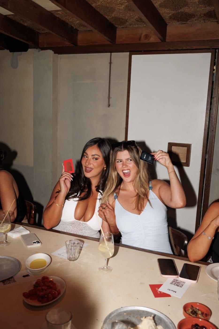 Two guests at the bar holding a Marlo card