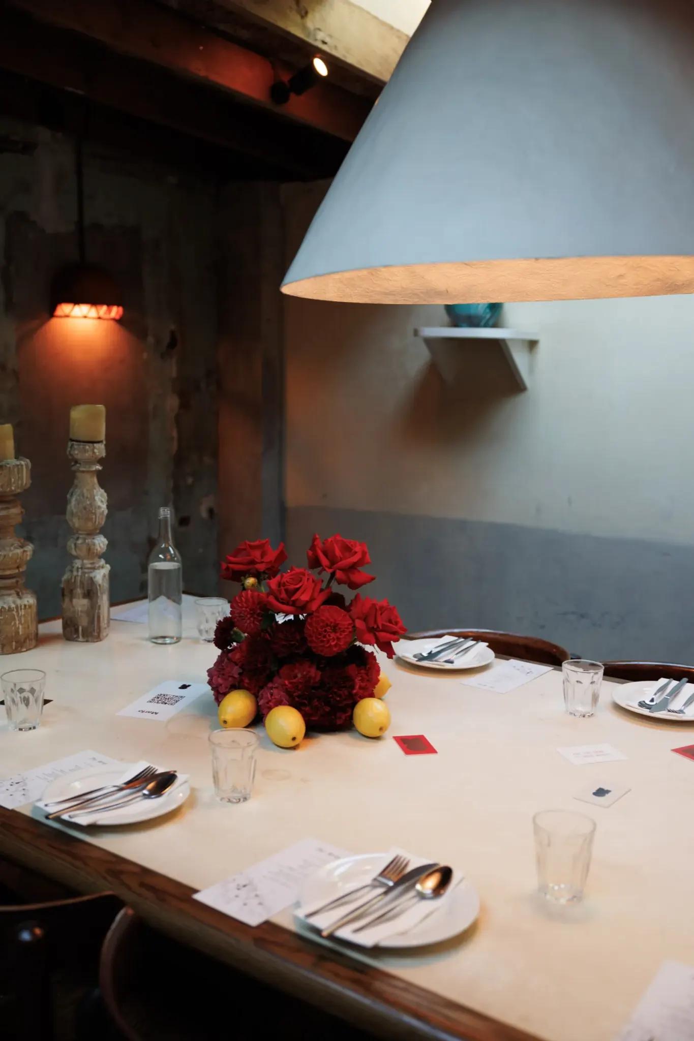 A laid table under a wide pendant shade
